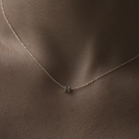 Solid gold and sterling silver jewellery: Video of a model wearing our signature 9ct yellow gold tiny letter H charm necklace on a 40cm cable chain